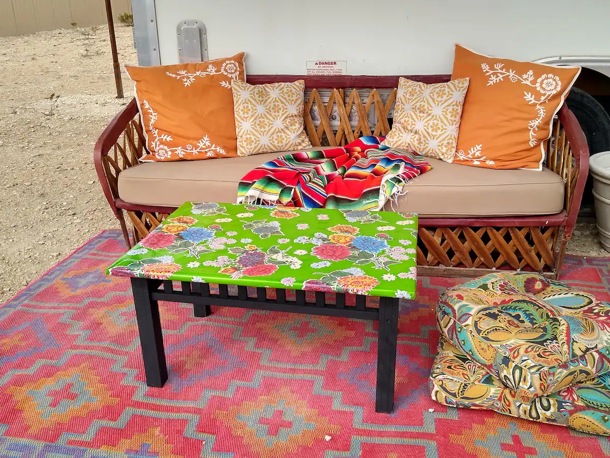 0433c21a-1323-476d-a600-9c515c4725d9 A colorful table and bench in the middle of an outdoor area.