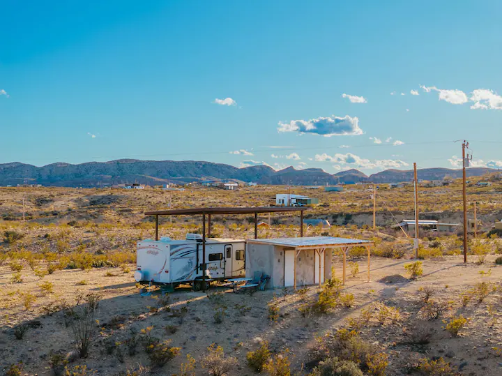 92c006af-95d7-4f7a-8195-5c992864cc85 A trailer park with a lot of trees in the background